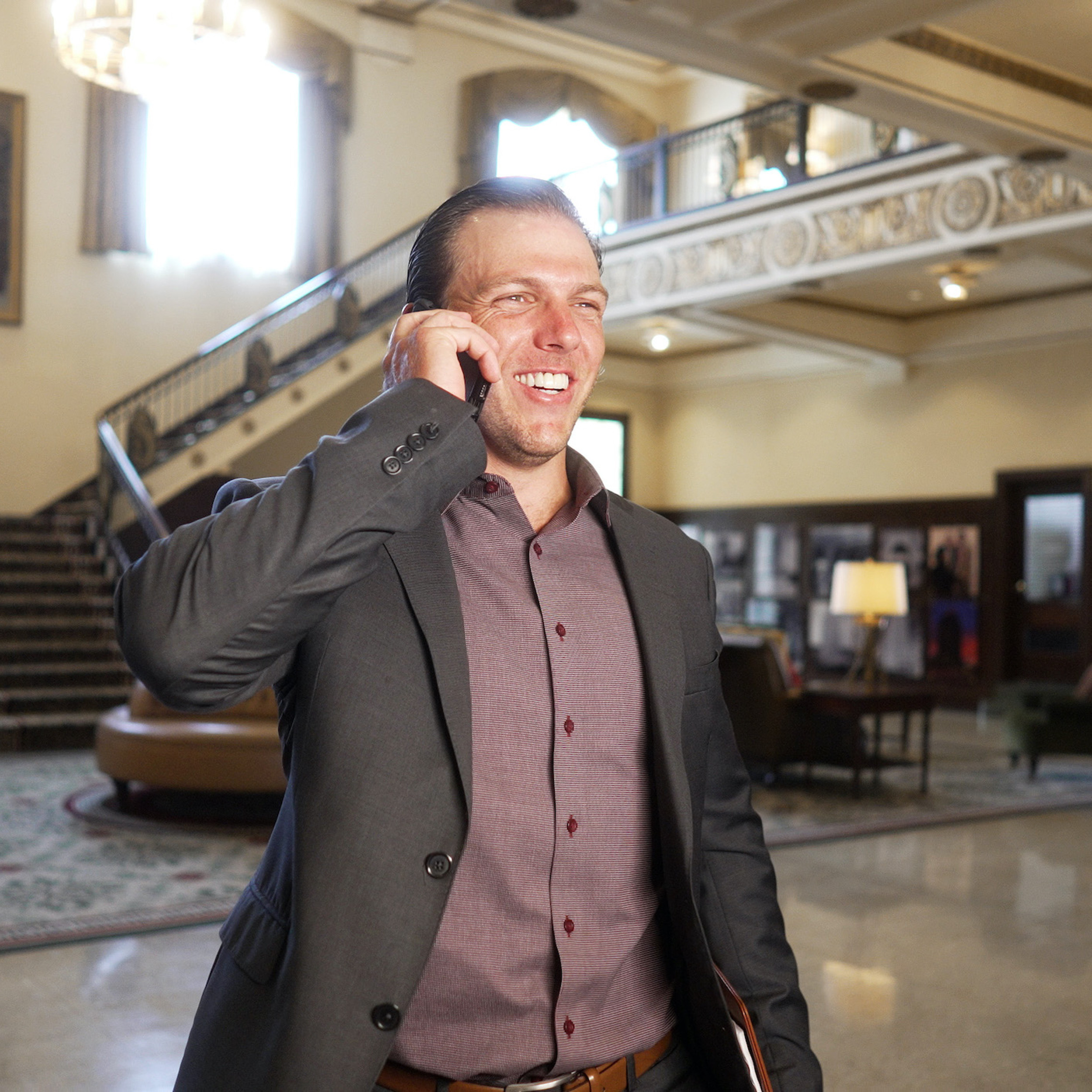 Man talking on the phone walking through a lobby